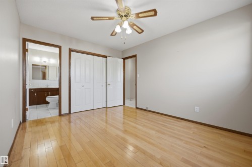 Wood-finish flooring, ceiling fan with integrated lighting, bi-fold closet doors, and recessed lighting in the bathroom - 14008 94 Street Nw, Edmonton, AB 