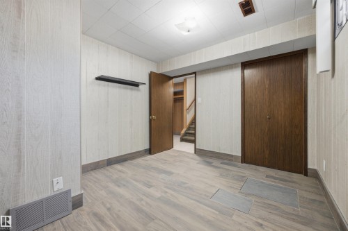 Light wood-finish flooring with a drop ceiling - 14008 94 Street Nw, Edmonton, AB 