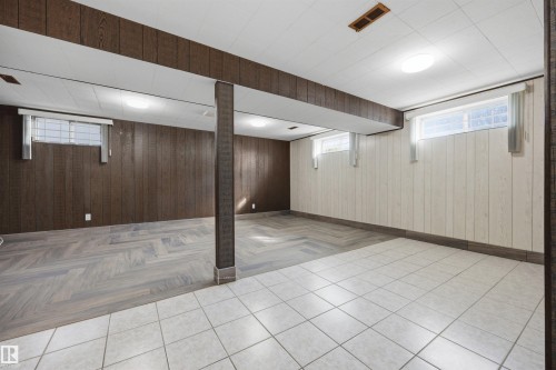 Spacious finished lower level featuring a dropped ceiling, recessed lighting, and a mix of wood-finish and tile flooring - 14008 94 Street Nw, Edmonton, AB 