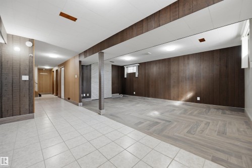 Expansive finished lower level featuring a combination of tile flooring and wood-finish flooring in a herringbone pattern - 14008 94 Street Nw, Edmonton, AB 