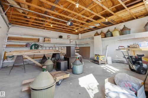 Concrete flooring, exposed wood beam ceiling, white-painted walls, overhead track lighting, and built-in shelving - 14008 94 Street Nw, Edmonton, AB 