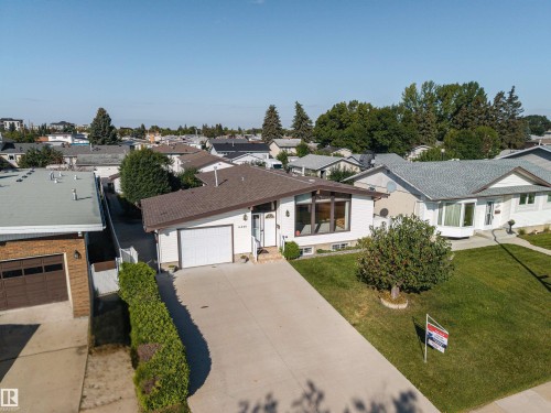 White exterior siding with a brown shingle roof, attached garage, and a concrete driveway - 14008 94 Street Nw, Edmonton, AB 
