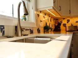 Stainless steel kitchen sink with a contemporary brushed nickel faucet - 