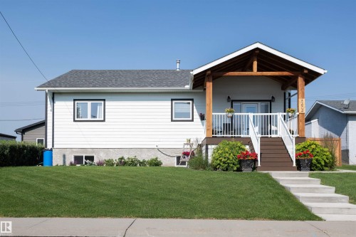 White siding exterior with a prominent covered front porch featuring exposed wood beams - 5404 60Th Street, Barrhead, AB - Outdoor