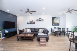 Open-concept living area featuring wood-finish flooring, recessed lighting, and two ceiling fans - 