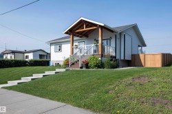 White siding exterior with a prominent covered front porch featuring exposed wood beams - 