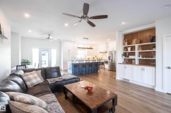 Open-concept living area featuring wood-finish flooring, recessed lighting, and ceiling fans - 