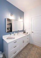 Expansive double vanity with a bright white countertop, white shaker cabinetry, and an undermount sink - 