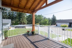 Covered porch featuring wood-finish decking and a natural wood-beamed ceiling - 