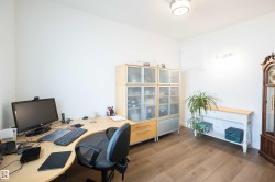 Room featuring wood-finish flooring, white walls, and a semi-flush ceiling light fixture - 