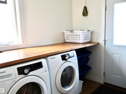 Dedicated laundry area with a wood-finish countertop - 