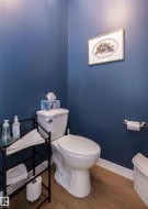 Powder room featuring deep blue walls and wood-finish flooring - 