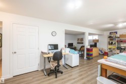 Spacious room with wood-finish flooring, white paneled doors, recessed lighting, and an open concept layout - 