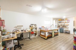Spacious room featuring wood-finish flooring, white walls, and built-in shelving - 