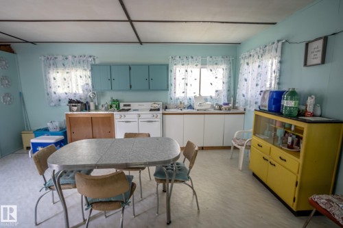 Kitchen area featuring light blue walls, white paneled ceilings, and vinyl flooring - 811 59209 Range Rd 95A, Rural St. Paul County, AB - Indoor Photo Showing Dining Room