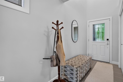 Entryway featuring a white door with decorative glass, light gray walls, and tile flooring - 5130 Godson Close Nw, Edmonton, AB 