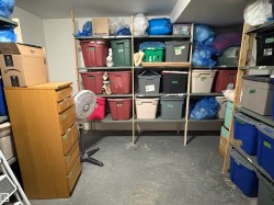 Utility space featuring concrete flooring and extensive shelving - 