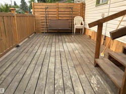 Spacious wood deck featuring wood railings and privacy fencing - 