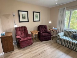 Spacious room featuring light wood-finish flooring, neutral-toned walls, and a large window with natural light - 