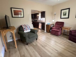 Open concept living area featuring light wood-finish flooring and neutral wall tones - 