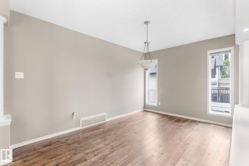 Wood-finish flooring, neutral wall tones, white trim, and a built-in chandelier - 2060 Brennan Crescent Nw, Edmonton, AB 