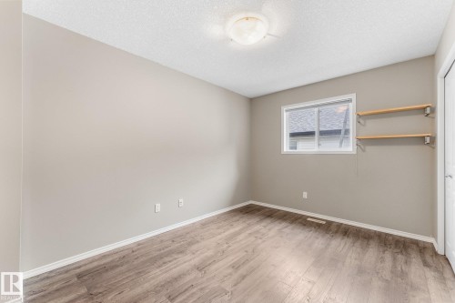 Wood-finish flooring, neutral wall paint, and a textured ceiling - 2060 Brennan Crescent Nw, Edmonton, AB 