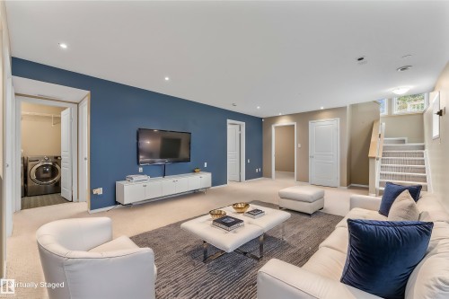 Recessed lighting, wall-mounted television, built-in entertainment console, carpeted flooring, and a laundry area with appliances - 2060 Brennan Crescent Nw, Edmonton, AB 