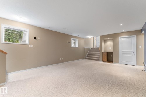 Carpeted living area with recessed lighting, built-in cabinetry, and a window with blinds - 2060 Brennan Crescent Nw, Edmonton, AB 