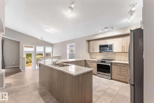 Vaulted ceiling, recessed lighting, tile flooring, wood-finish cabinetry, and stainless steel appliances - 2060 Brennan Crescent Nw, Edmonton, AB 