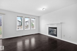 Dark wood-finish flooring, white walls, and a white subway tile fireplace with a mantel - 