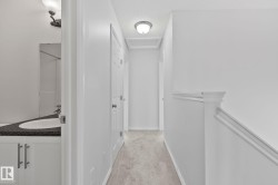 Hallway with neutral carpet, white walls, and flush mount lighting - 