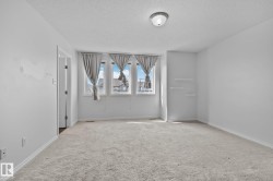 Light-colored carpeting, multiple windows providing natural illumination, and a ceiling-mounted light fixture - 