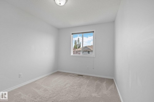 Neutral wall finishes with a window, wall-to-wall carpeting, and a ceiling-mounted light fixture - 9523 Simpson Crest Nw, Edmonton, AB 