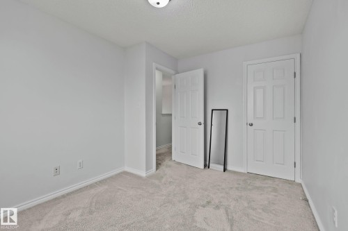 Light gray wall paint, off-white carpeting, white baseboards, and white paneled doors - 9523 Simpson Crest Nw, Edmonton, AB 