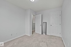 Light gray wall paint, off-white carpeting, white baseboards, and white paneled doors - 