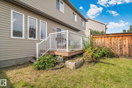 Raised wood deck with white railings, wood privacy fence, and multiple large windows - 9523 Simpson Crest Nw, Edmonton, AB 