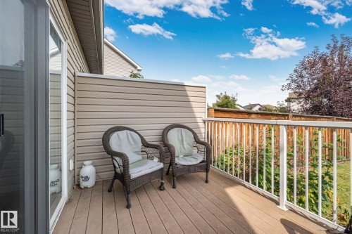 Deck with wood-finish flooring, white railing, and sliding glass door - 9523 Simpson Crest Nw, Edmonton, AB 