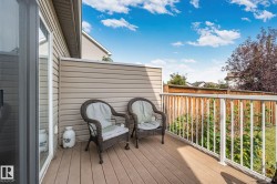 Deck with wood-finish flooring, white railing, and sliding glass door - 