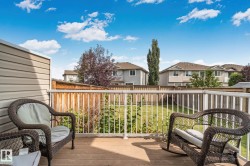 Composite decking with white and wood-tone railings overlooking a fenced backyard with a lawn - 