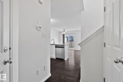 Open-concept layout with wood-finish flooring, a kitchen island, and stainless steel appliances - 