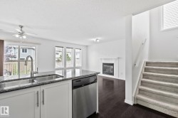Kitchen island with integrated sink, stainless steel dishwasher, and stone-finish countertop - 