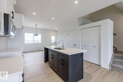 Kitchen island with dark cabinetry, integrated sink, and light-toned countertop - 