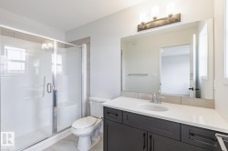 Bathroom featuring a dark wood-finish vanity with a white countertop, an undermount sink, and a chrome faucet - 
