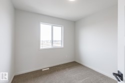 Neutral-toned carpet flooring and white baseboards - 