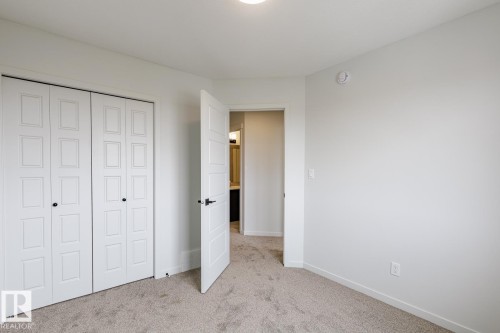 Neutral-toned carpeting complements clean white walls - 3603 40 Avenue, Beaumont, AB - Indoor