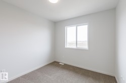 Neutral white walls with a single window and recessed ceiling light - 