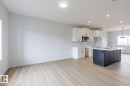 Open-concept living space featuring wood-finish flooring, recessed lighting, and a kitchen island with seating - 3603 40 Avenue, Beaumont, AB  - Indoor Photo Showing Kitchen 