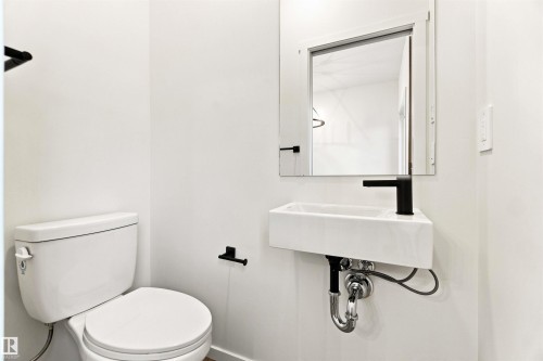 Wall-mounted rectangular sink with a matte black faucet and coordinating fixtures - 7097 Rosenthal Drive Nw, Edmonton, AB 