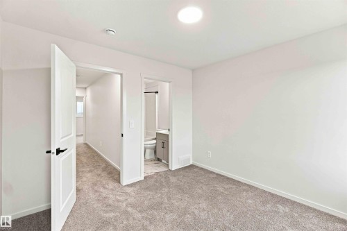 Plush carpeted flooring, white interior walls, recessed ceiling lighting, and matte black door hardware - 7097 Rosenthal Drive Nw, Edmonton, AB 