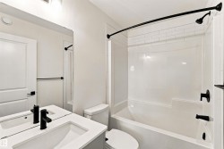 Vanity with integrated sink, matte black faucet, and white countertop - 